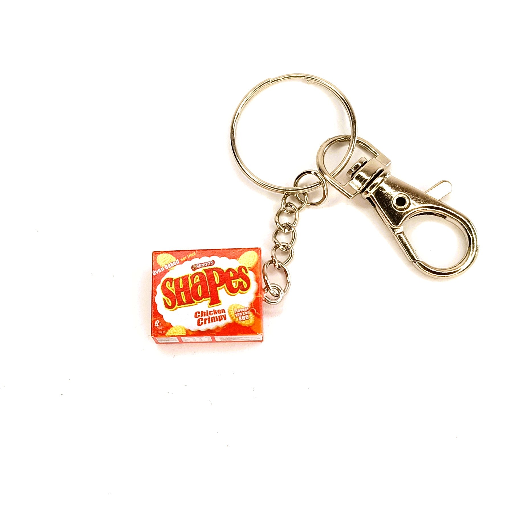 A novelty keychain featuring a miniature orange box of Arnott's Chicken Crimpy Shapes Shapes, attached to a silver metal split ring and lobster clasp on a white background.