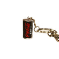 A miniature Coca-Cola Zero keychain featuring a black can design with the red and white logo, attached to a silver metal split ring and key clips on a plain white background.