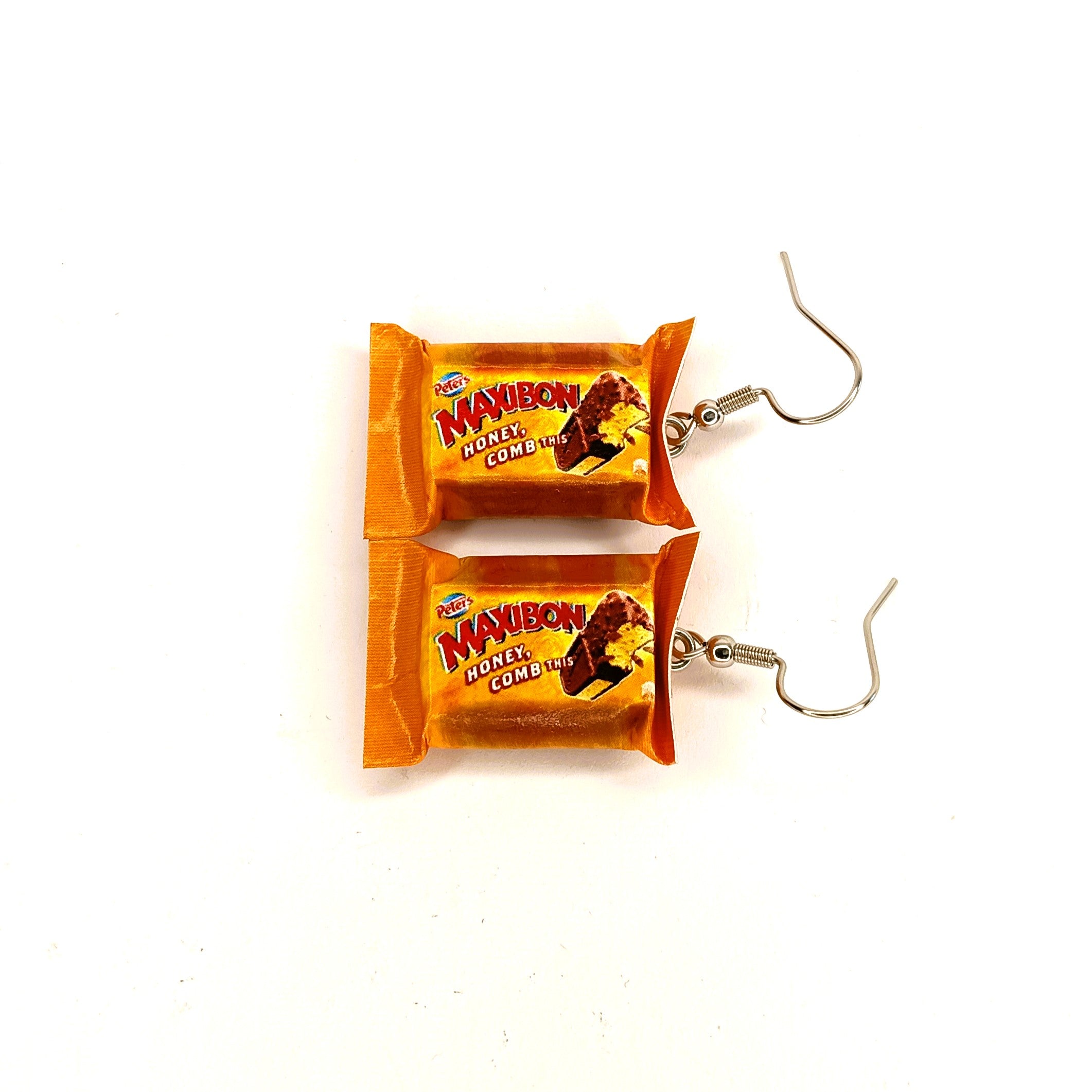 A pair of dangling earrings designed to look like miniature ice cream bars, featuring orange and yellow packaging with the 'Maxibon' brand logo and silver-tone hooks.