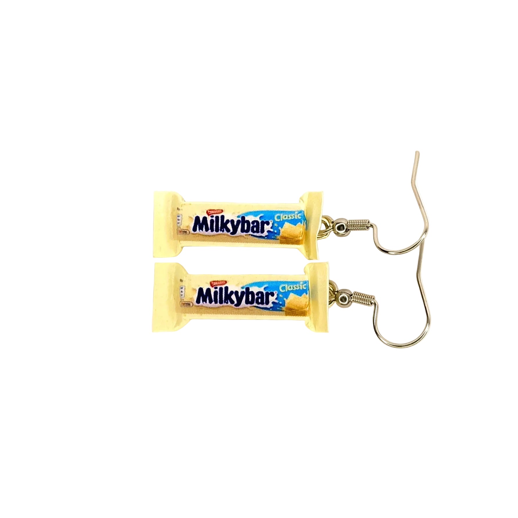A pair of novelty earrings designed to look like two wrapped Milkybar Classic chocolate bars, featuring cream wrappers and silver-tone fishhook wires, set against a plain white background.