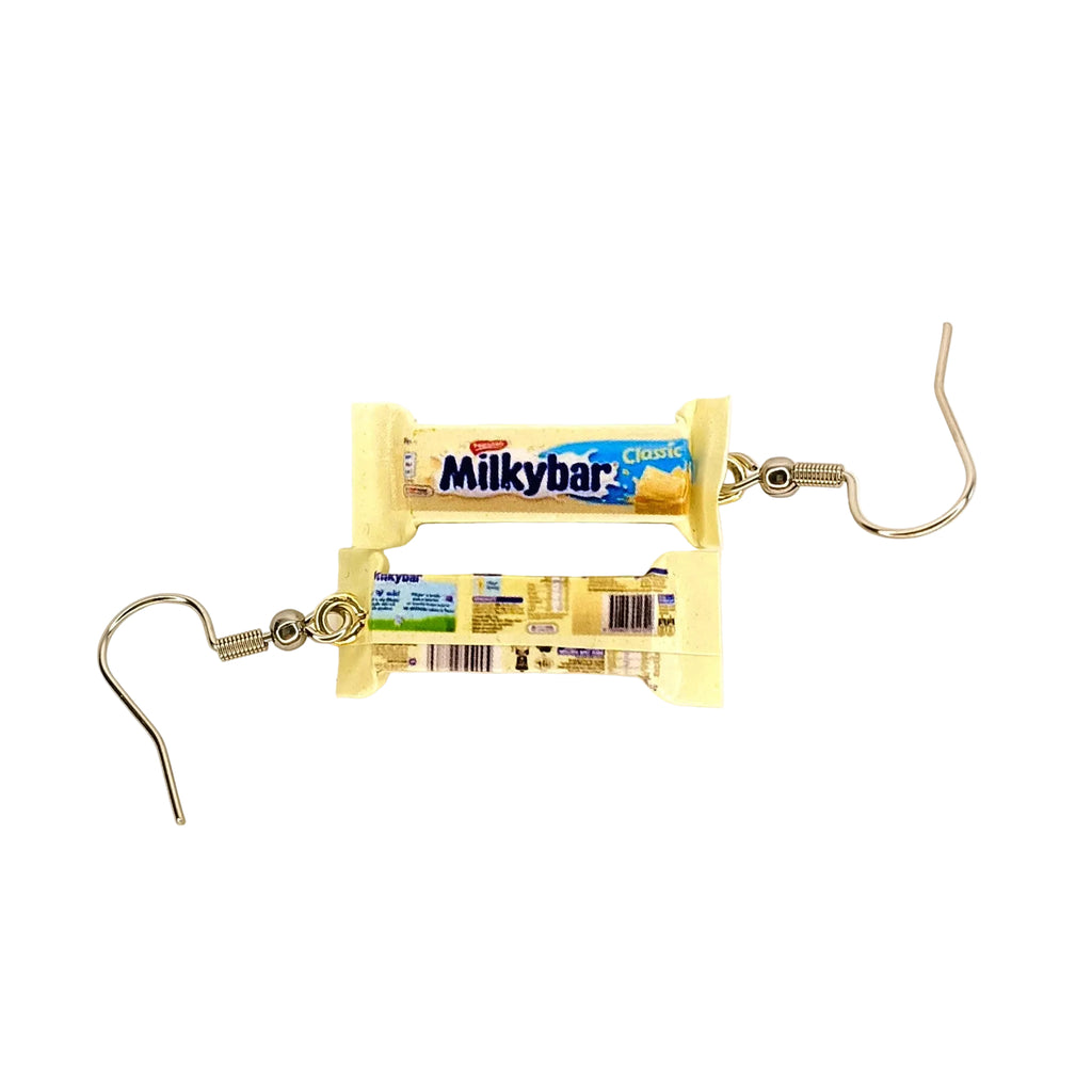 A pair of novelty earrings shaped like miniature Milkybar chocolate bars, featuring silver-tone wire hooks and small printed Milkybar wrappers, shown on a plain white background.