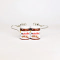 A pair of earrings designed to look like two small Nutella jars, with silver-tone wire hooks extending from the lids, shown on a plain white background.