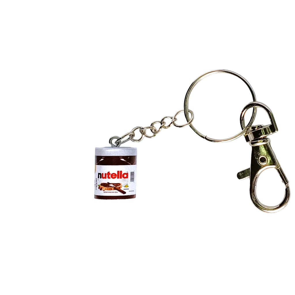 A novelty keychain shaped like a small jar of Nutella, featuring a white and brown label with the red Nutella logo, attached to a silver-tone metal split ring and lobster clasp on a white background.