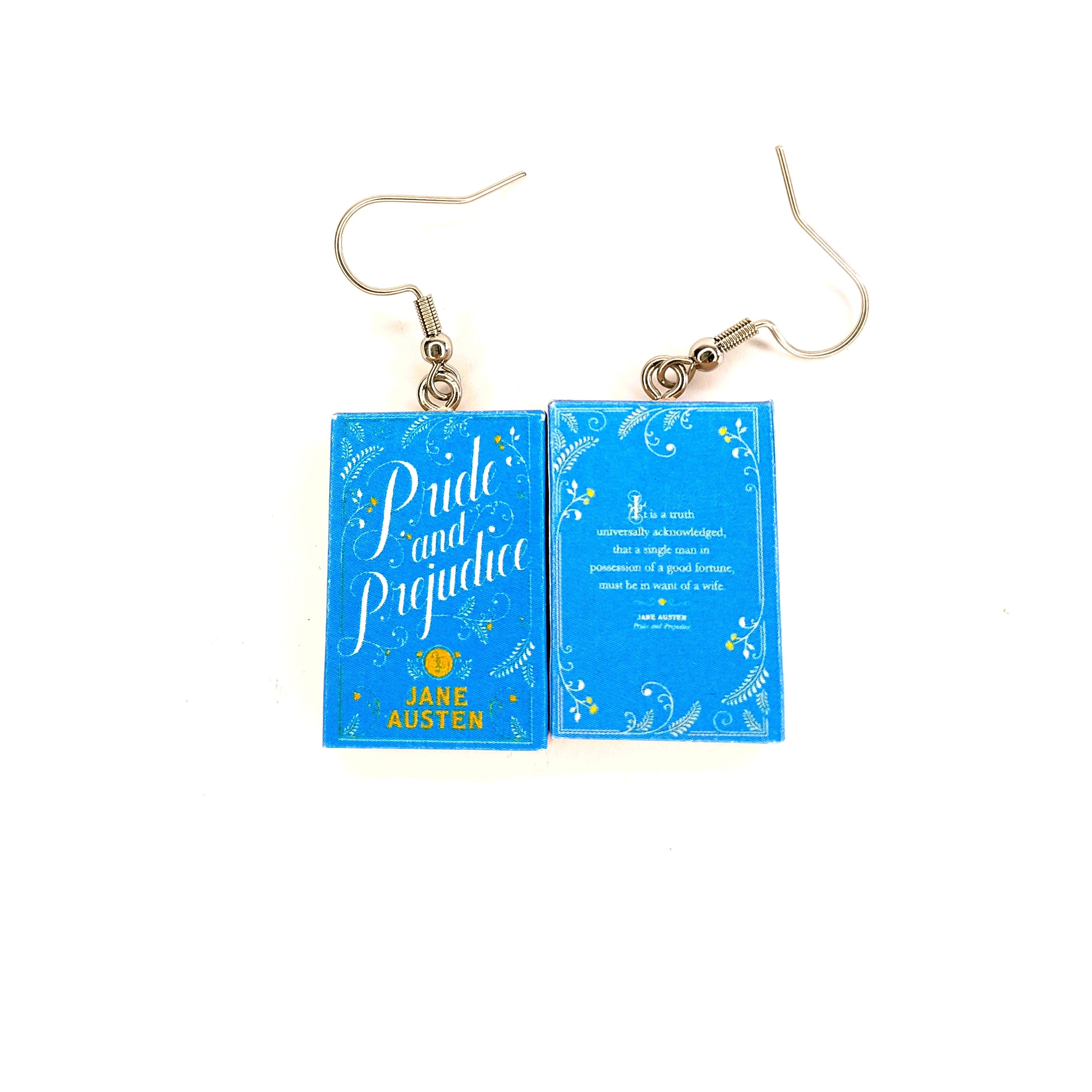 A pair of drop earrings shaped like the front and back covers of the book 'Pride and Prejudice', featuring silver-tone fishhook wires on a plain white background.